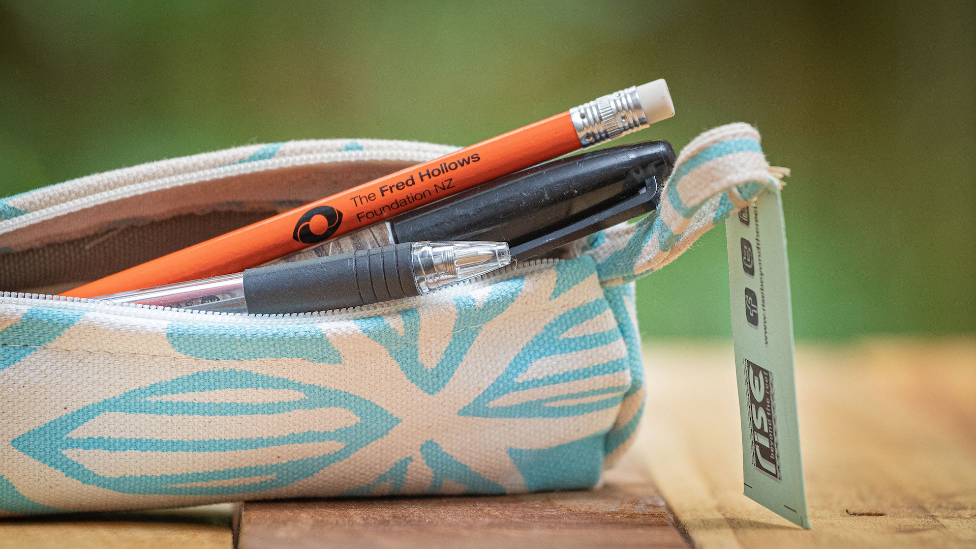 A close up of the canvas pencil case with a Fred Hollows Foundation NZ branded pencil