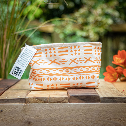 A handmade canvas pouch with orange print